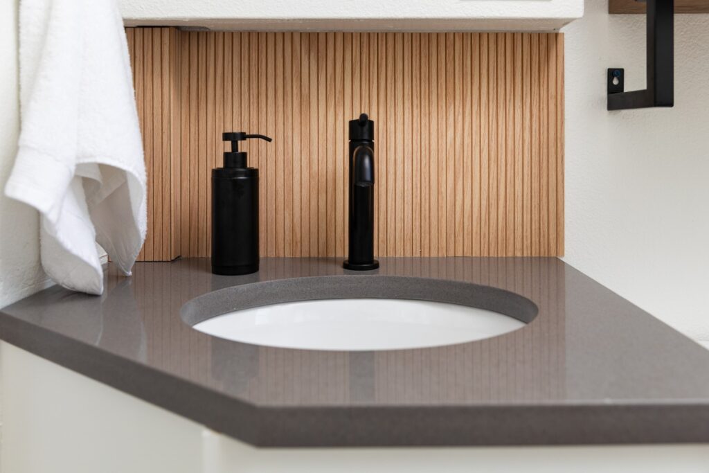 Modern bathroom sink with black faucet and soap dispenser