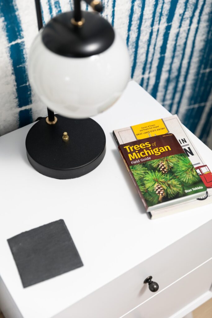 Books and lamp on white nightstand