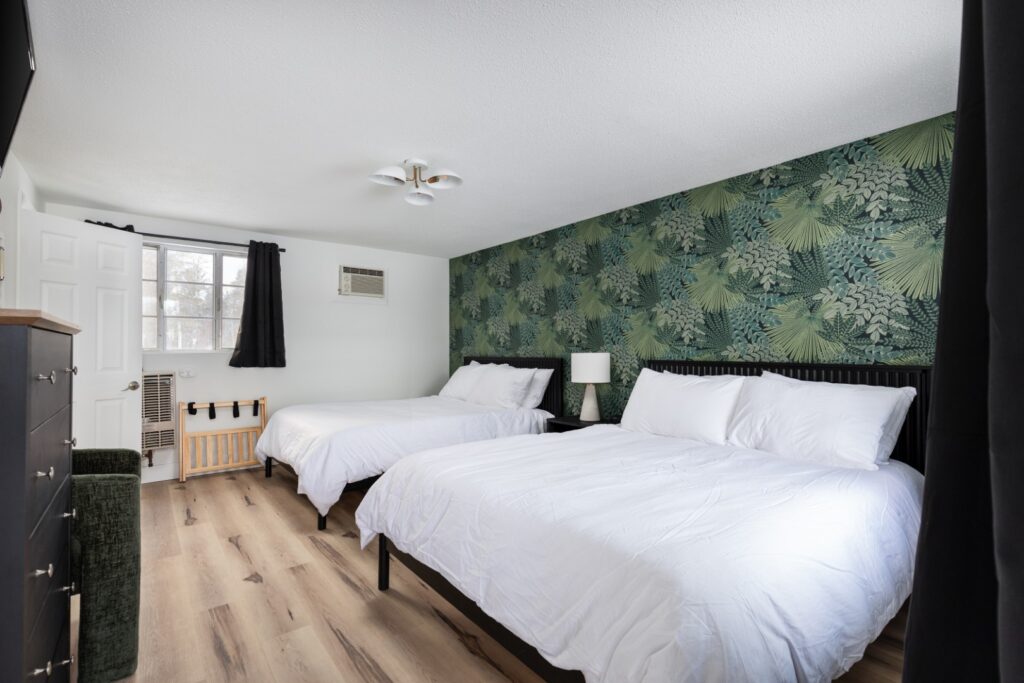 Bedroom with two beds and tropical wallpaper
