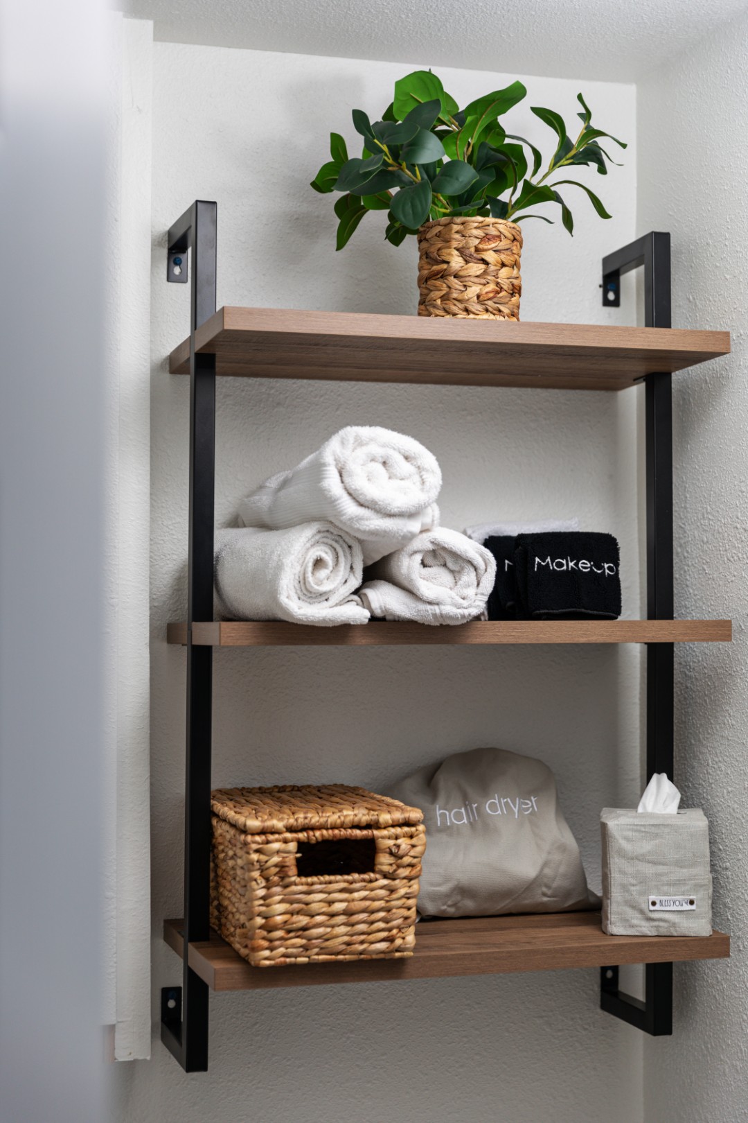 Bathroom shelf with towels and plant decor