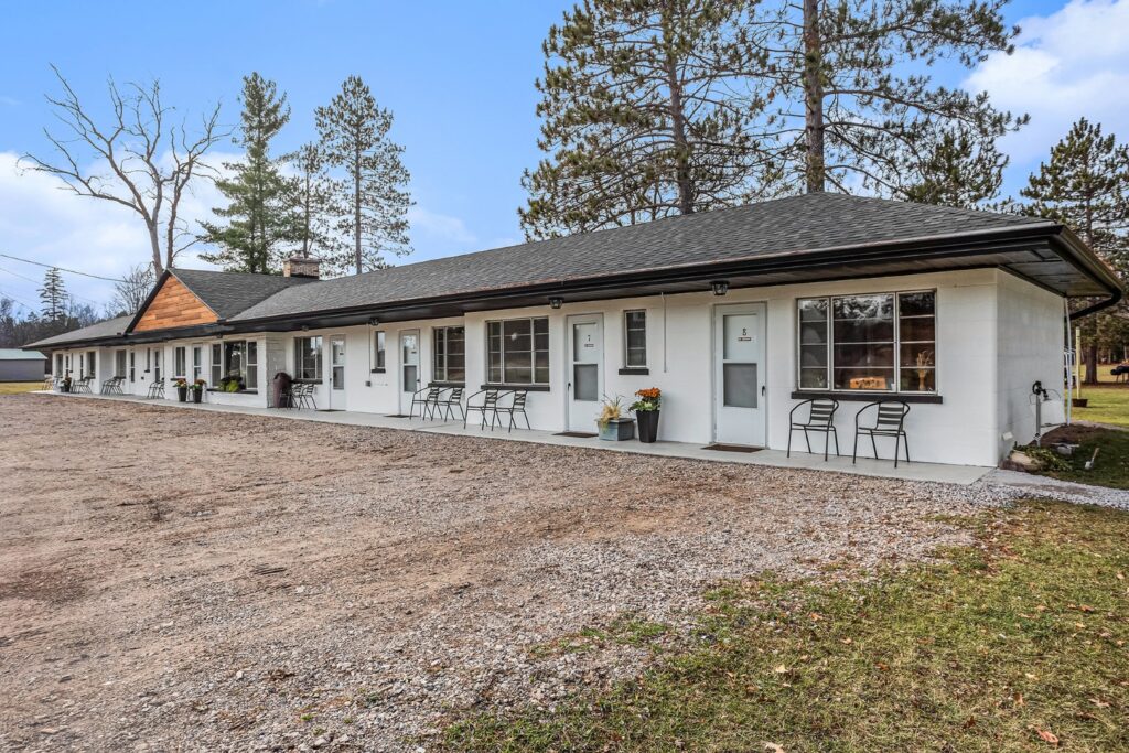 Single-story motel building with outdoor seating