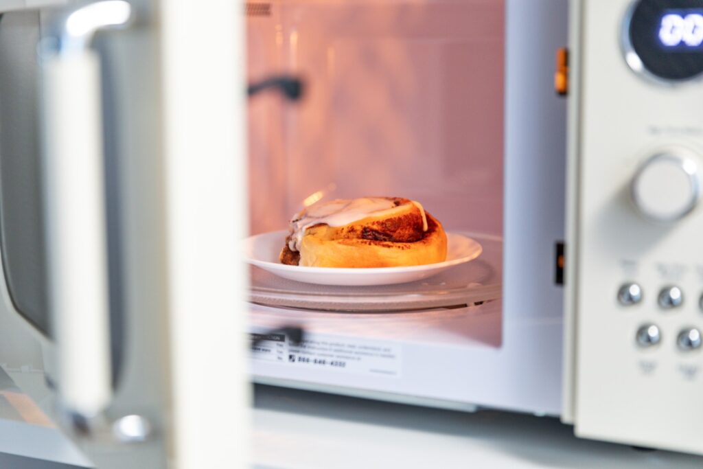 Cinnamon roll heating in a microwave oven