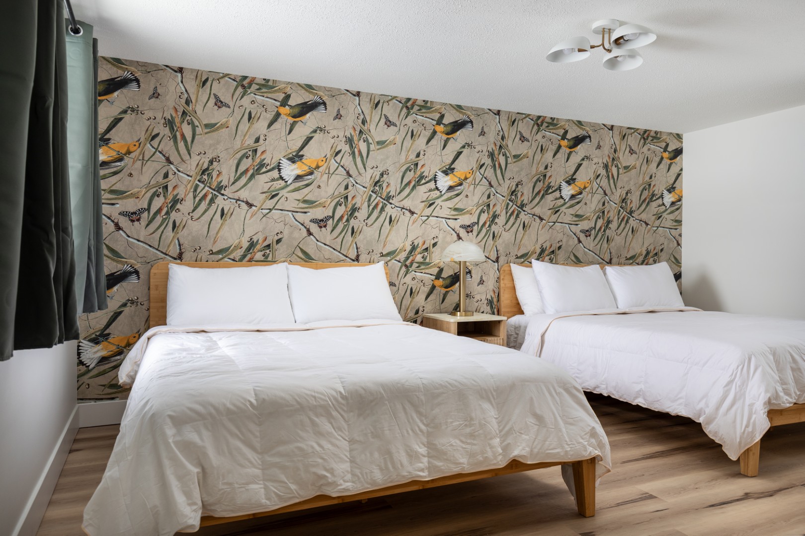 Bedroom with two beds and bird wallpaper