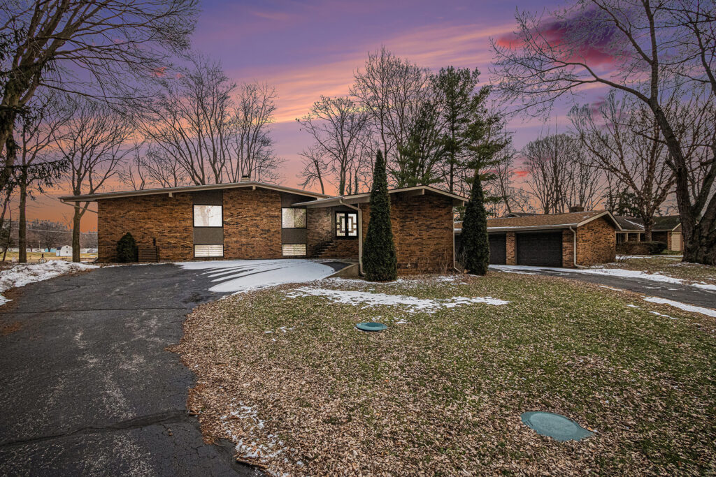 Brick house with driveway at sunset