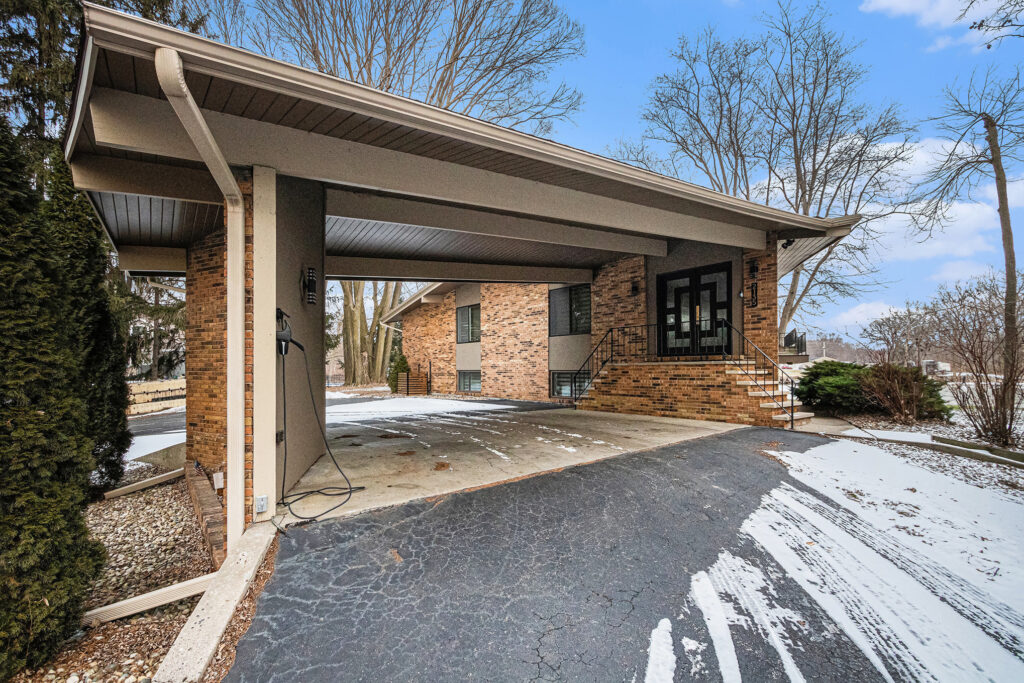 Brick house with covered driveway in winter