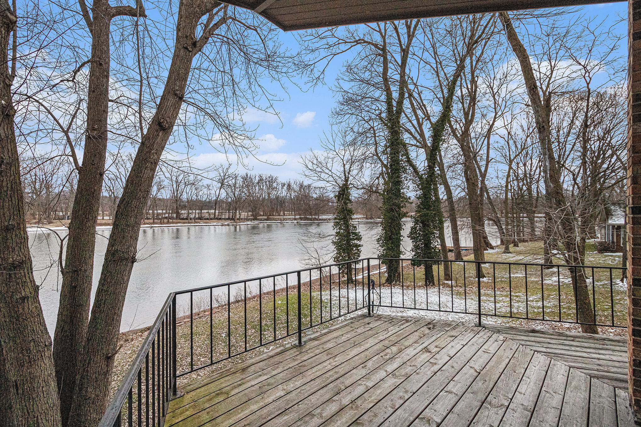 Wooden deck overlooking river and trees in winter
