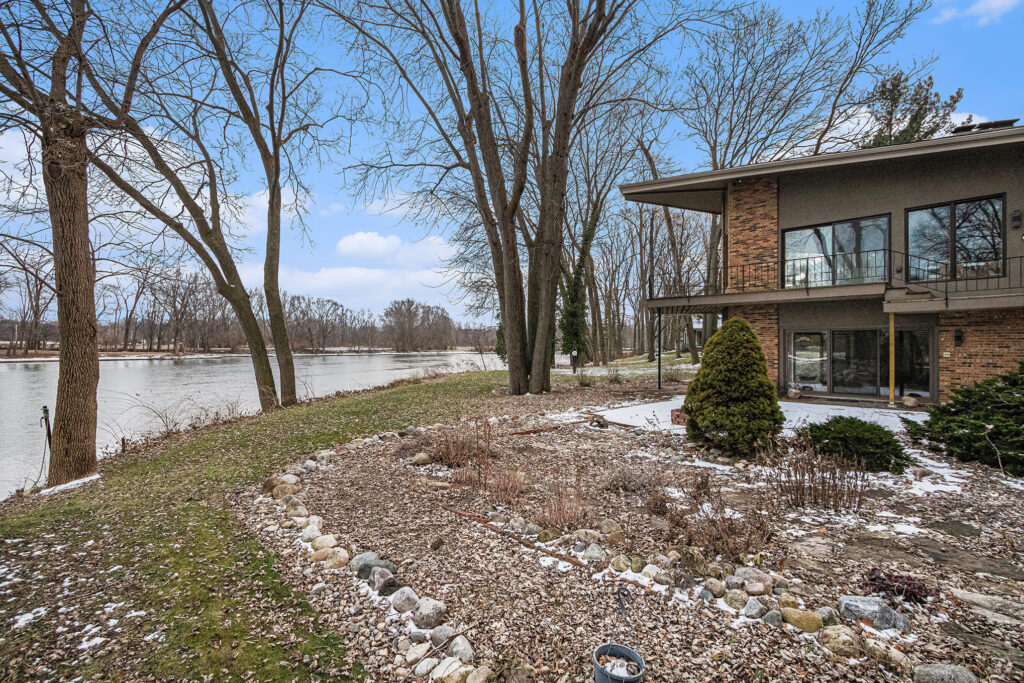 Riverside house with trees and winter landscape