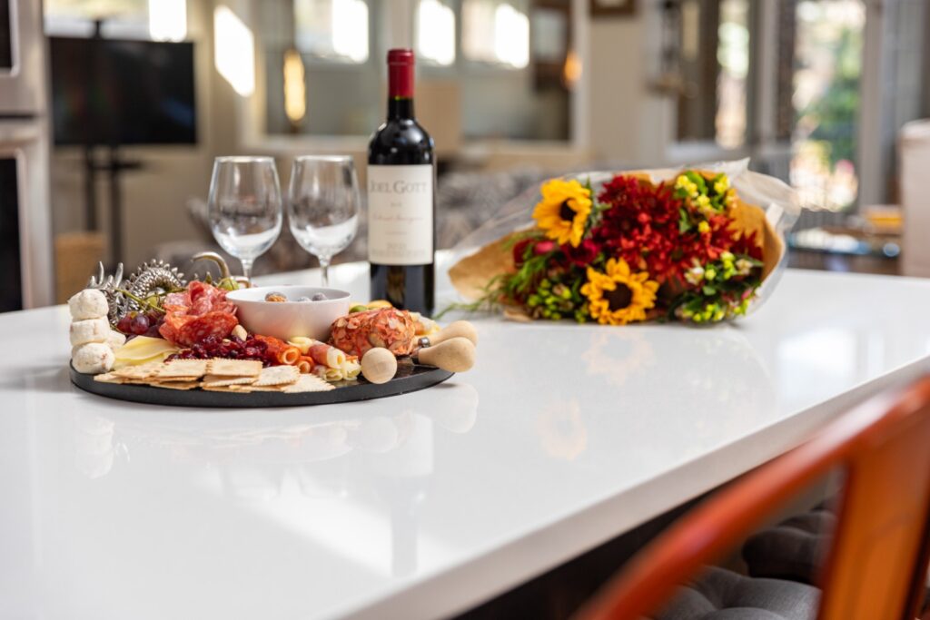 Wine, charcuterie board, and flowers on table