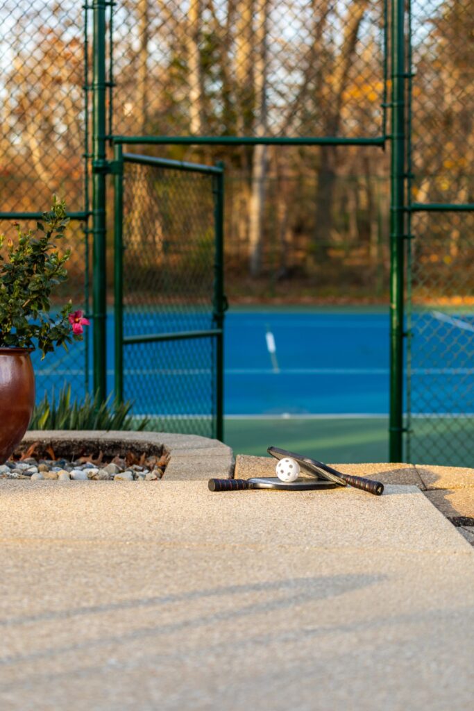 Pickleball paddles and ball near outdoor court