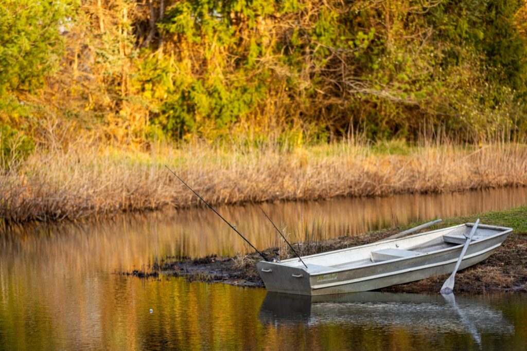 Fishing boat by calm riverside in autumn