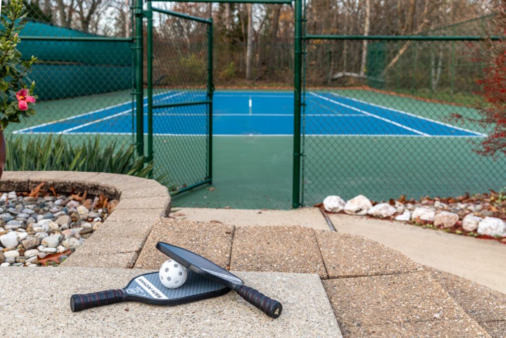 Pickleball paddles and ball near outdoor court