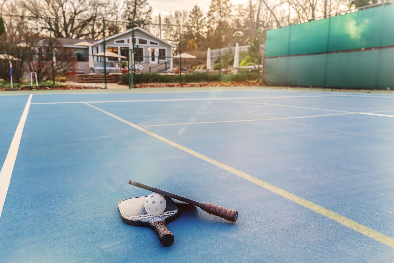 Pickleball paddles and ball on outdoor court