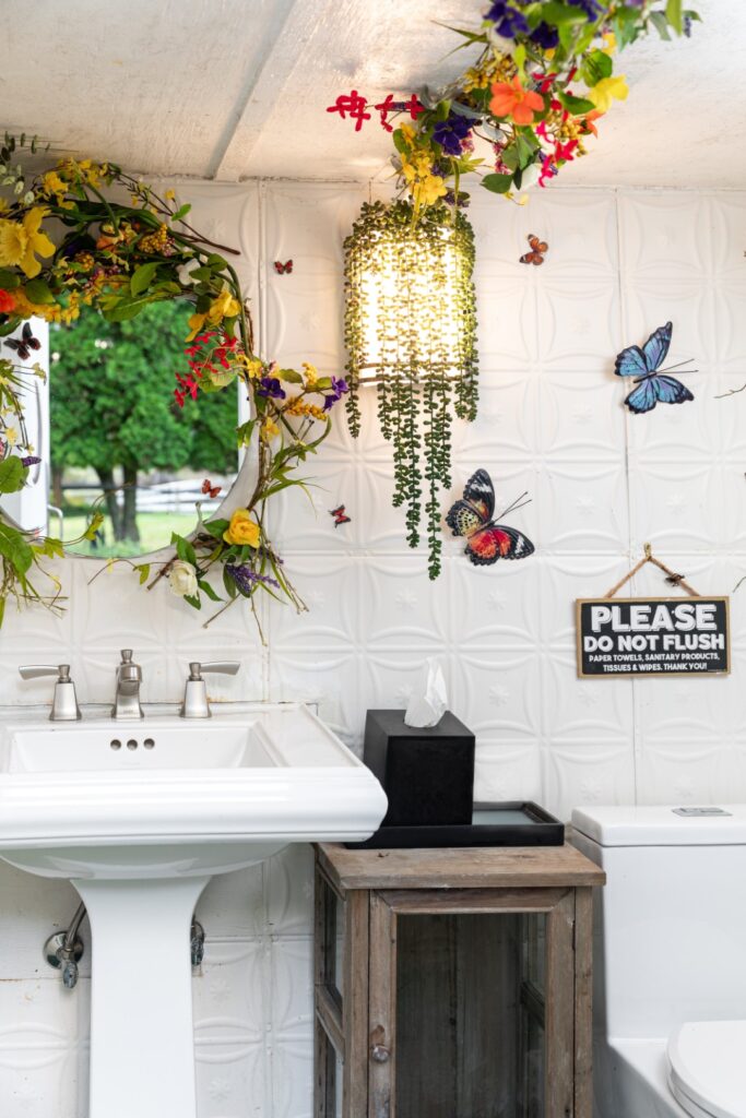 Colorful floral bathroom decor with butterflies and mirror.
