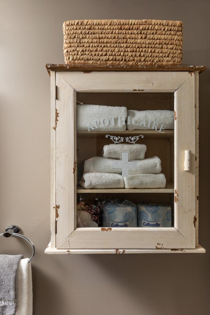 Rustic bathroom cabinet with towels and toilet paper