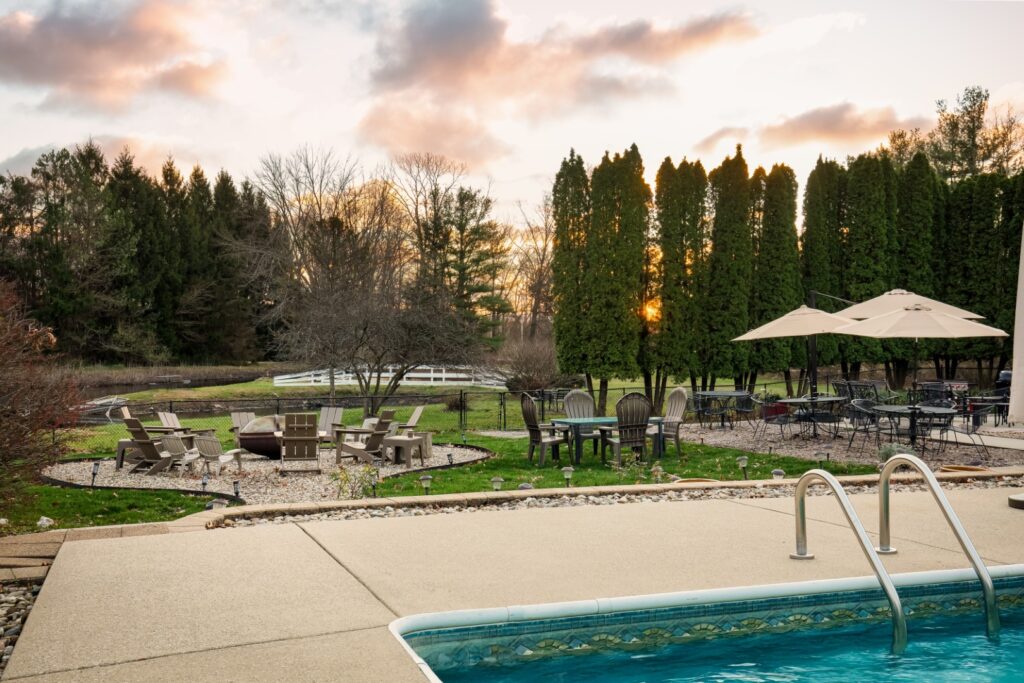 Backyard pool with patio seating at sunset