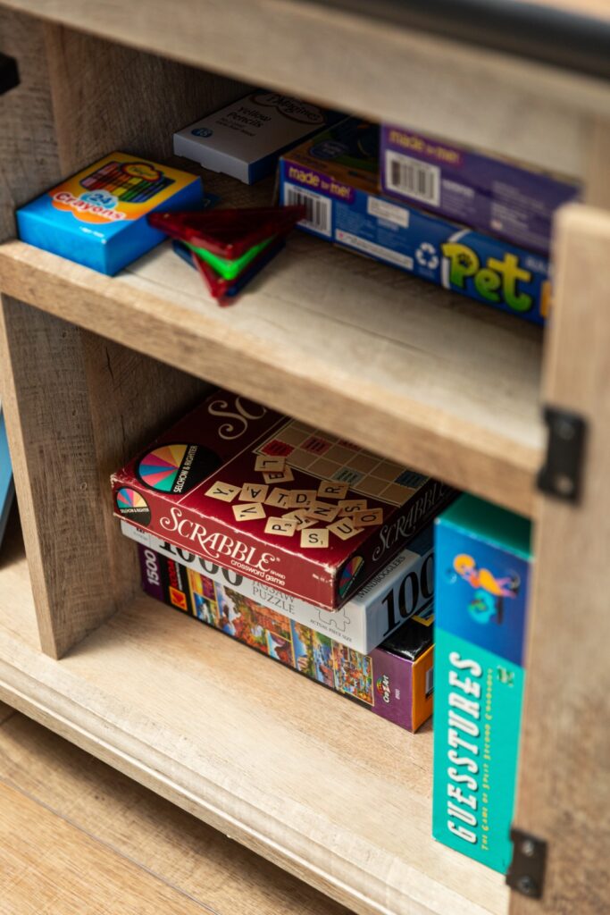 Board games and puzzles on wooden shelf