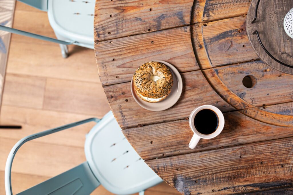Bagel and coffee on rustic wooden table