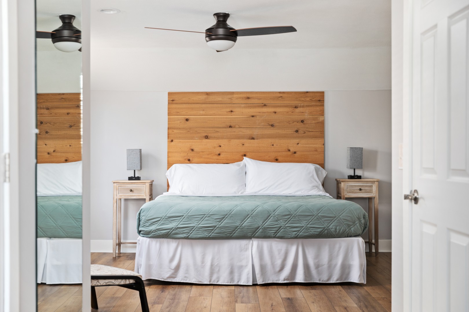 Modern bedroom with wooden headboard and ceiling fan