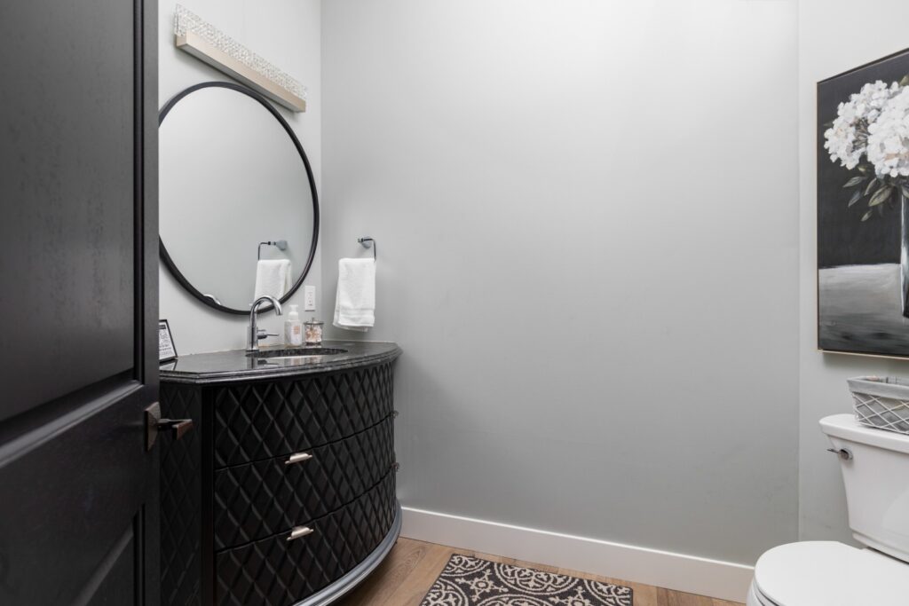Modern bathroom with black vanity and round mirror