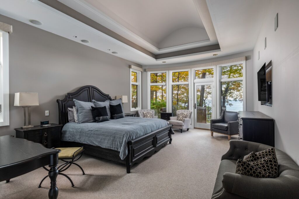 Modern bedroom with large windows and lake view