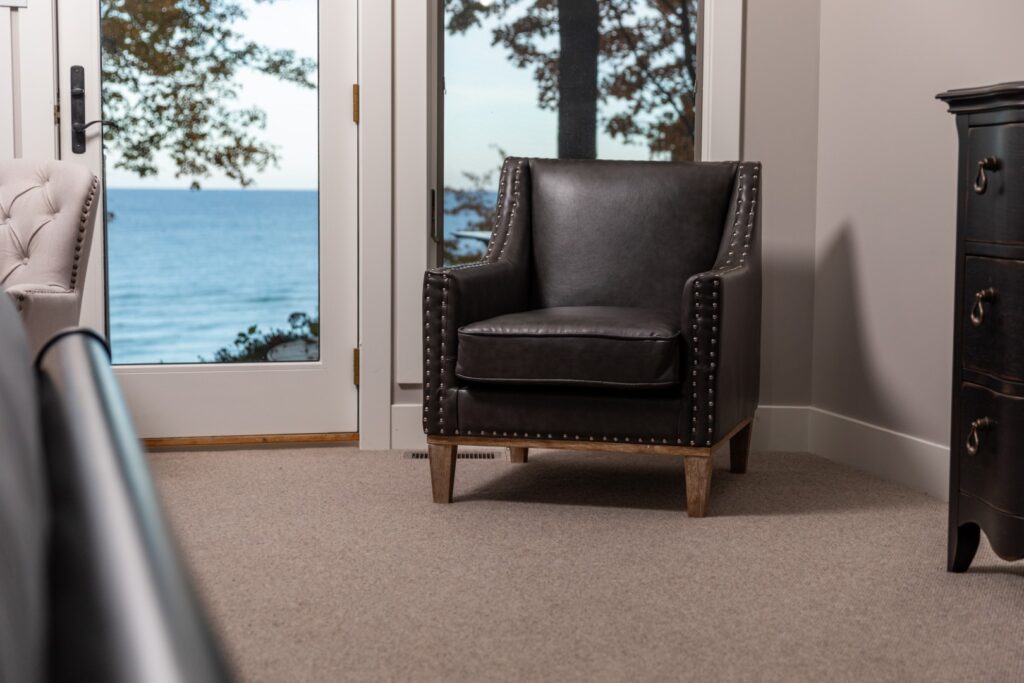 Black leather armchair beside window with ocean view