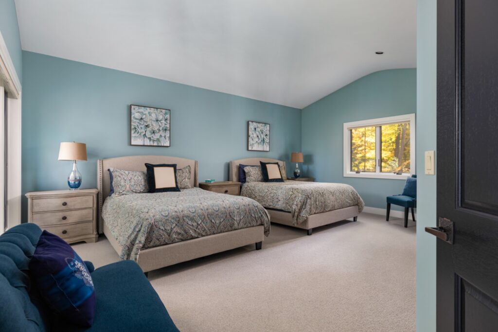 Modern bedroom with two beds and blue decor