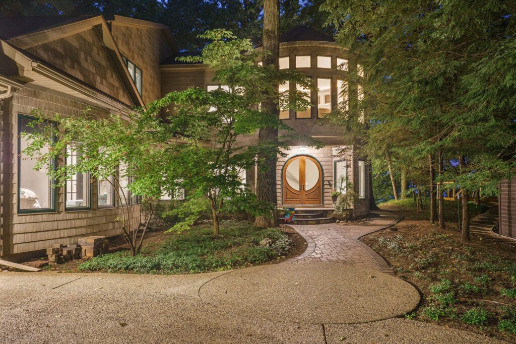 Modern house exterior surrounded by trees at night