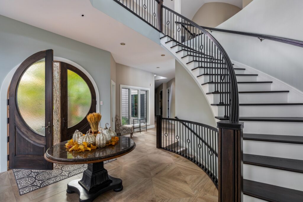 Modern foyer with curved staircase and round door