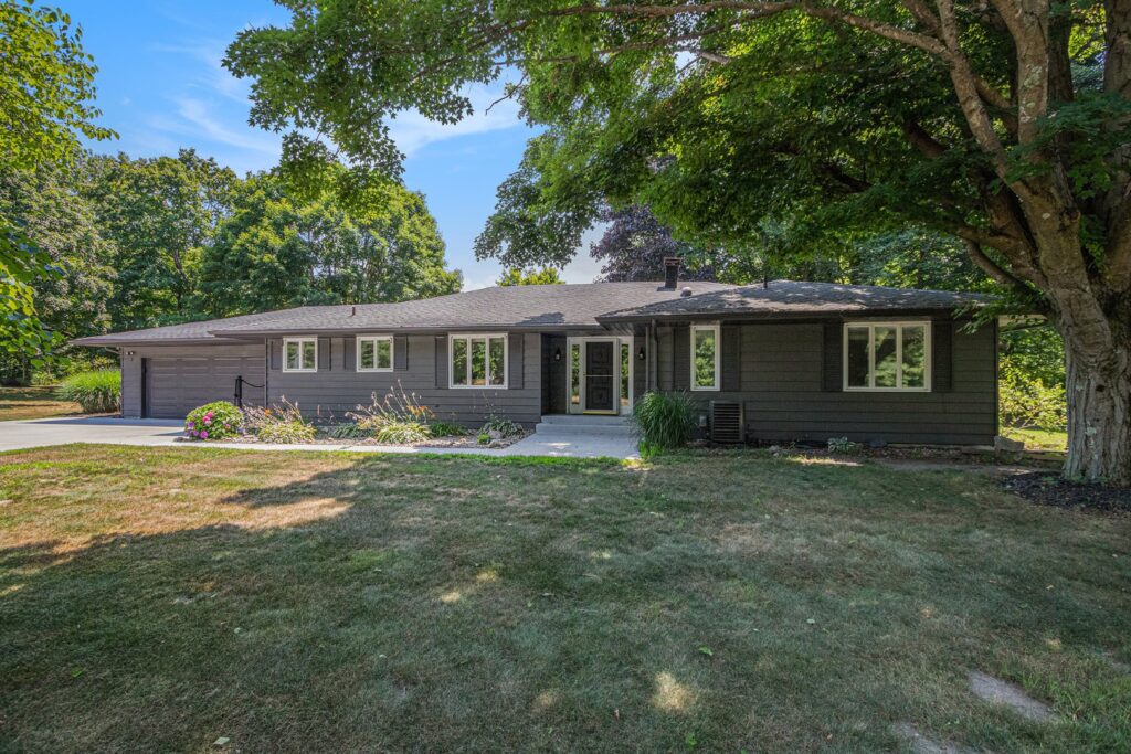 Single-story gray house with front yard trees