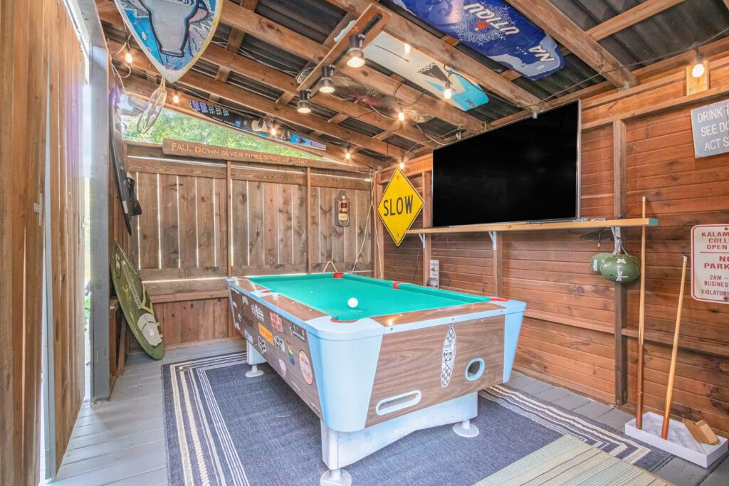 Rustic game room with pool table and TV