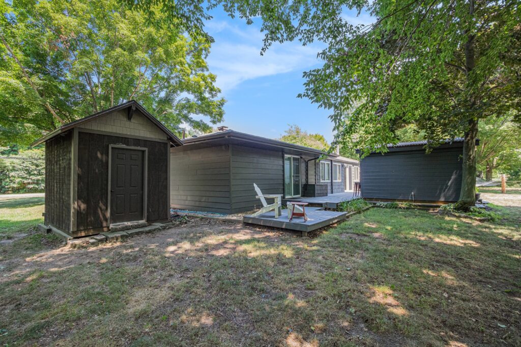 Wooden cabin with deck in green yard