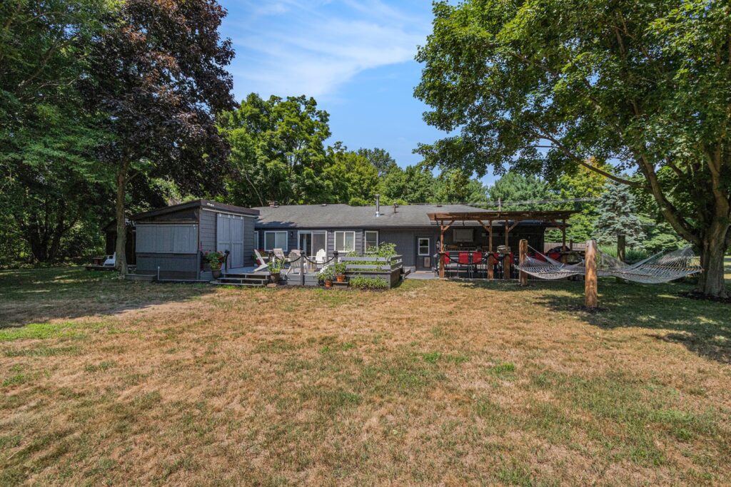 Backyard view of house with deck and hammocks