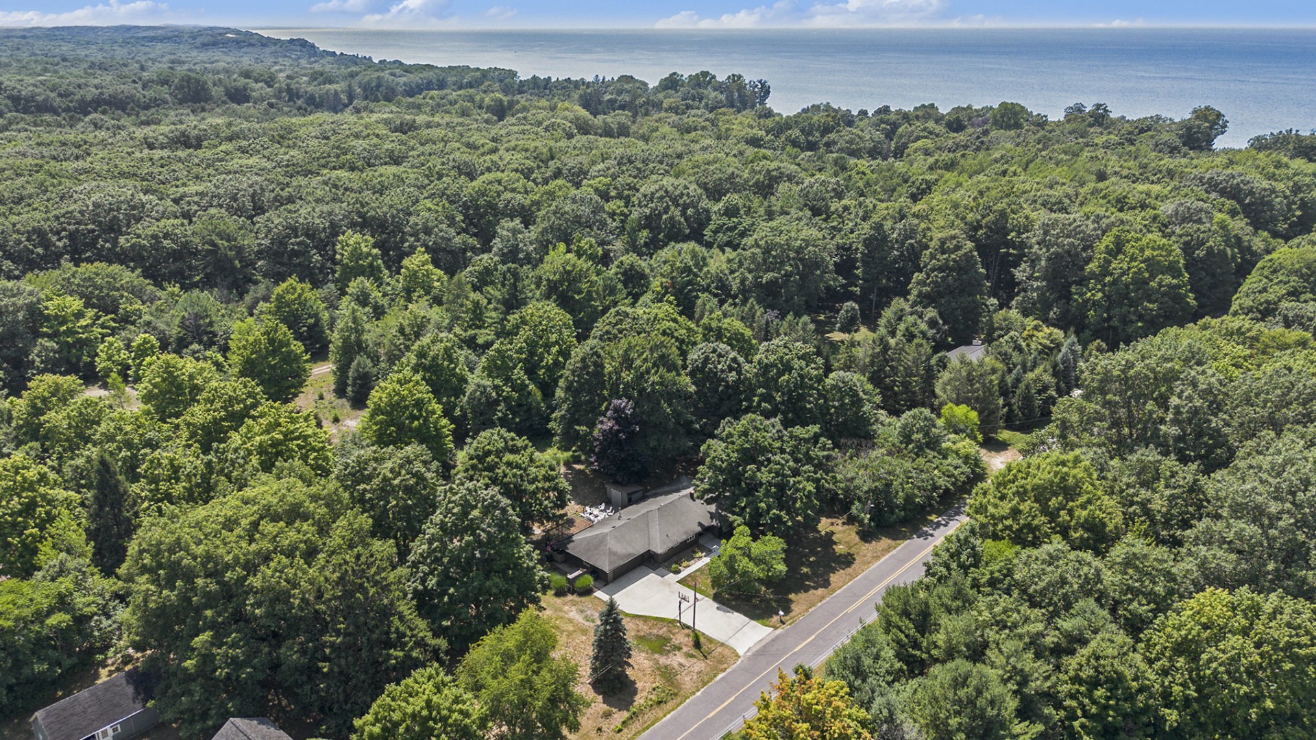 House surrounded by forest near lake shoreline