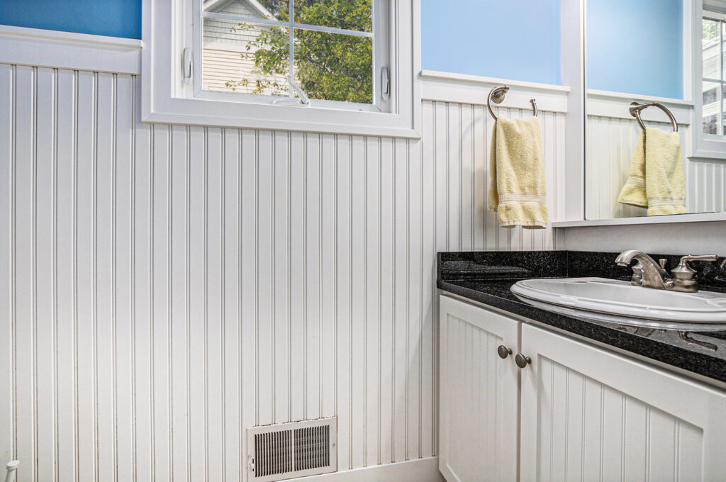 Bright bathroom with white wainscoting and black countertop