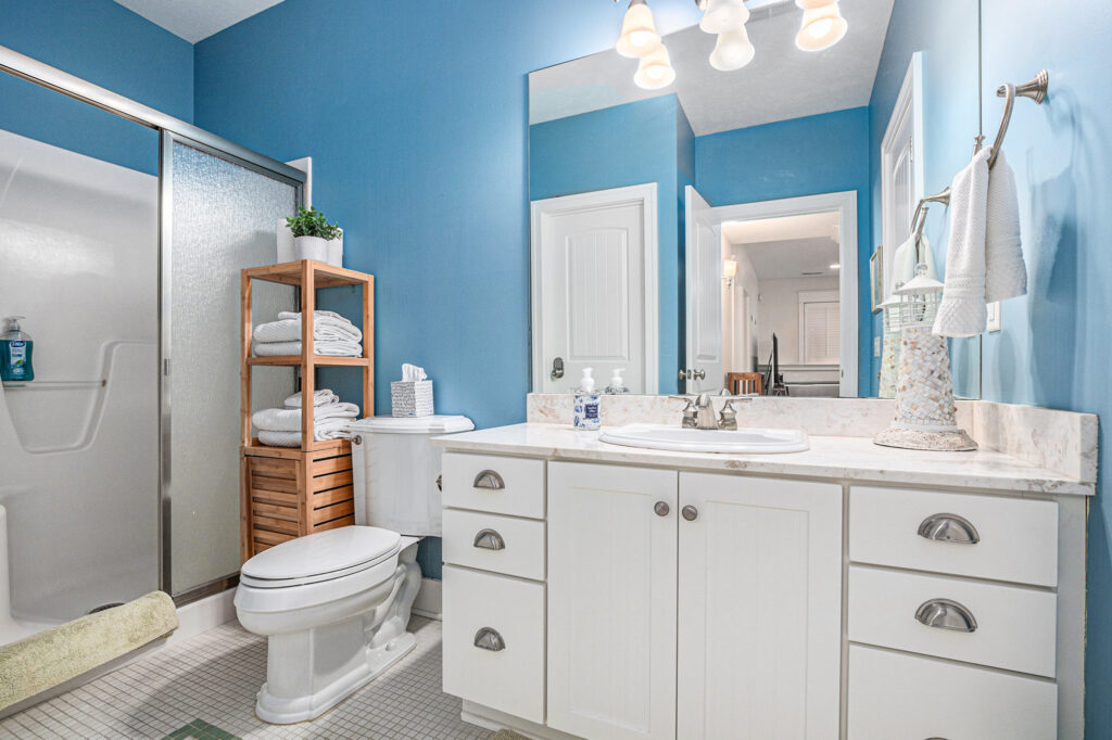 Modern blue bathroom with white vanity and shower