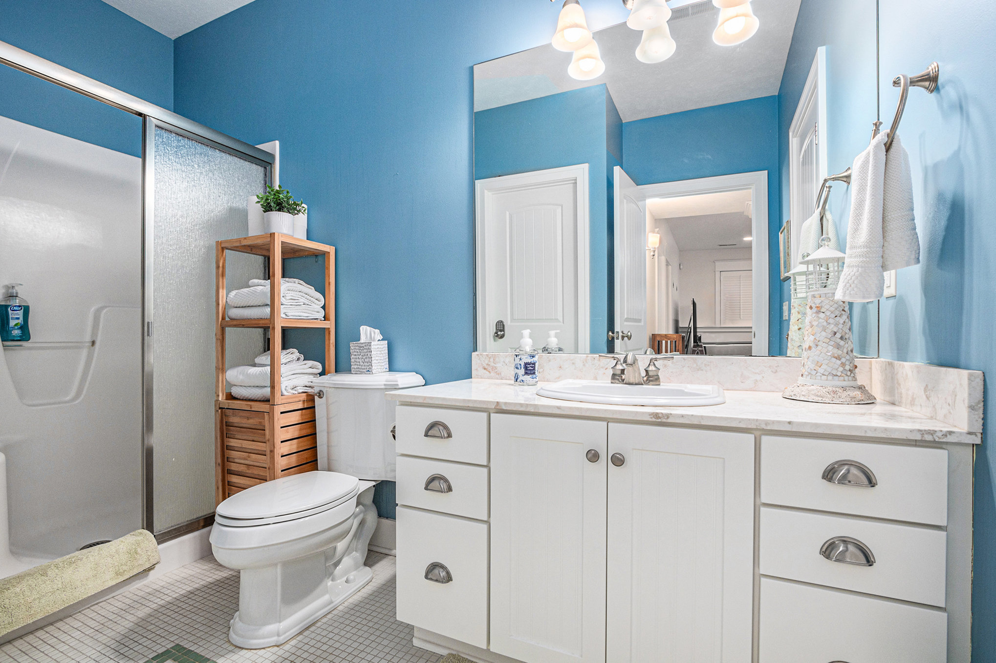 Modern blue bathroom with white vanity and shower