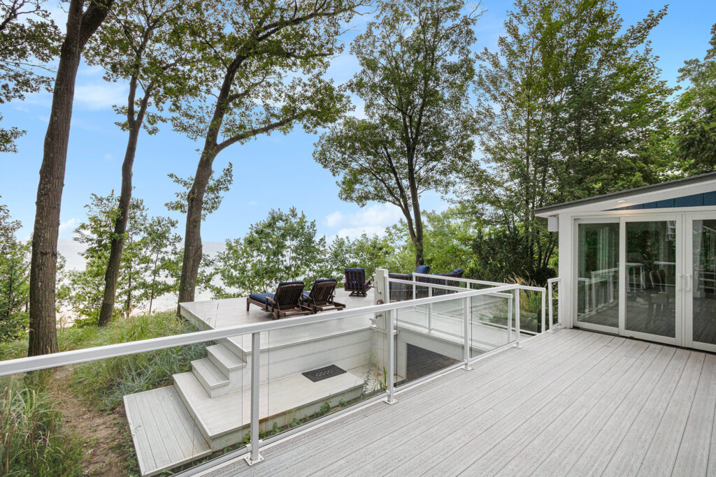 Modern deck overlooking lake with lounge chairs