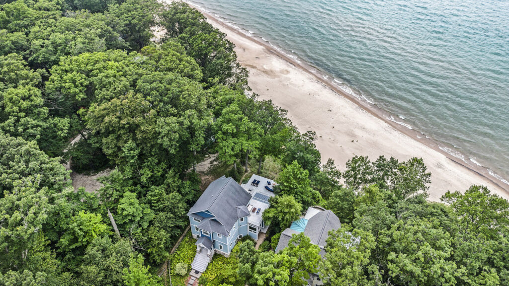 Beachfront house surrounded by trees and shoreline
