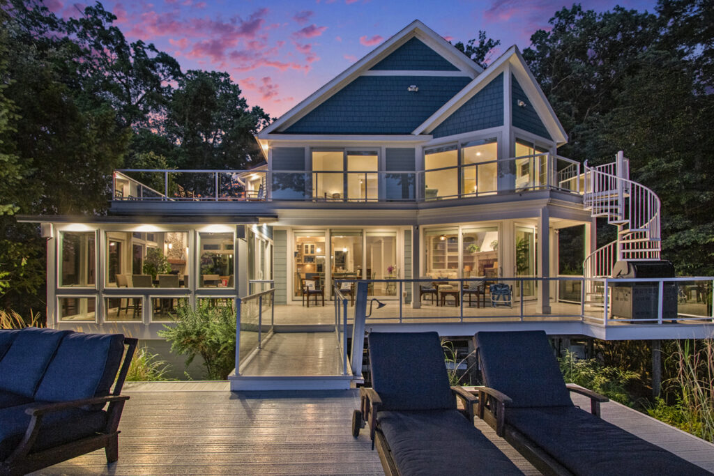 Modern lake house with large glass windows at sunset