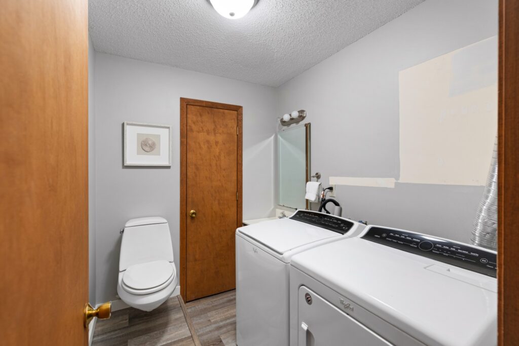 Laundry room with washer, dryer, and toilet
