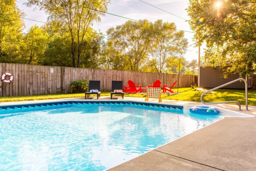Sunny backyard with swimming pool and lounge chairs