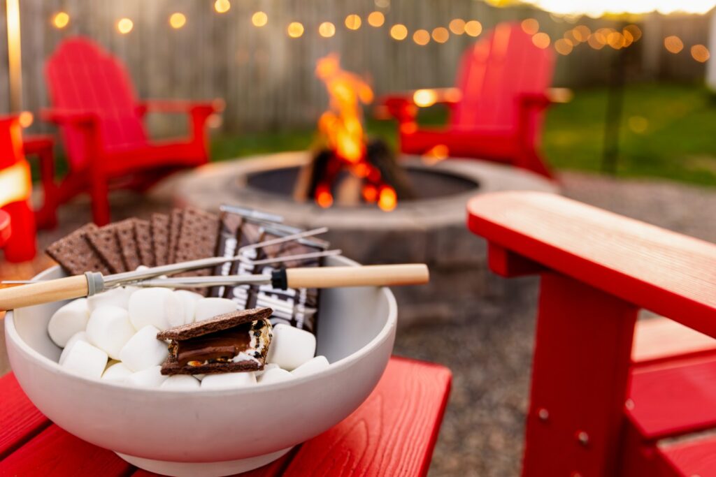 S'mores by campfire with red chairs outdoors