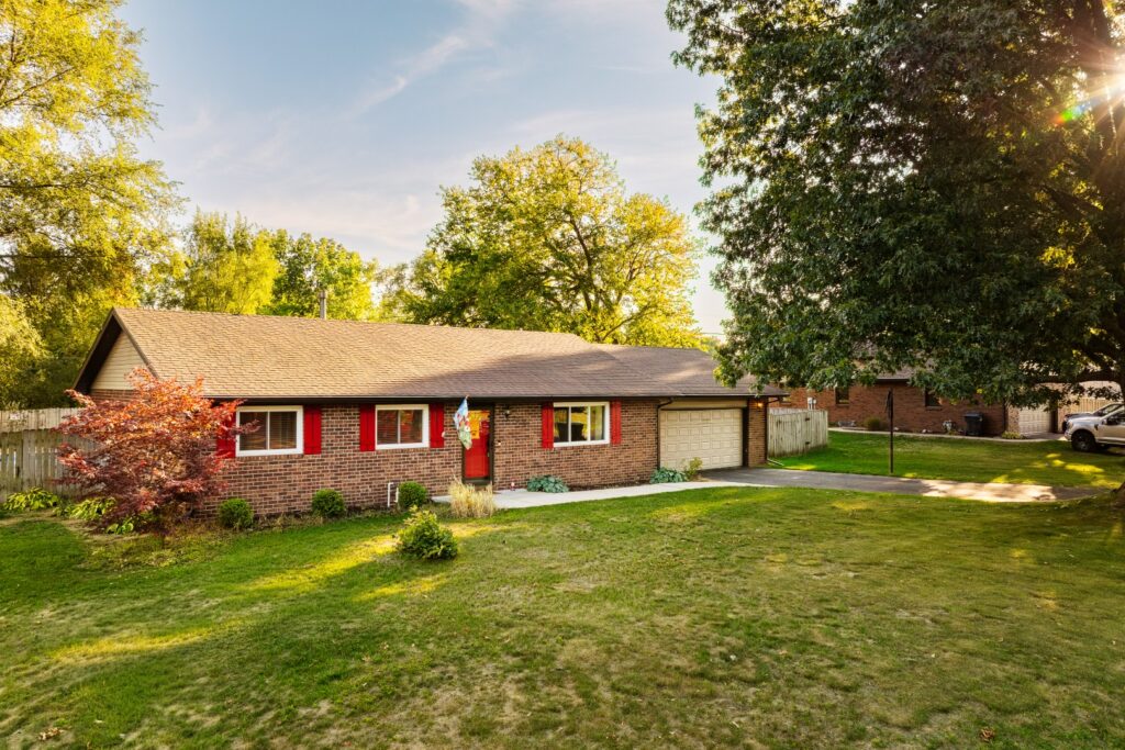 Brick suburban house with red shutters and garage