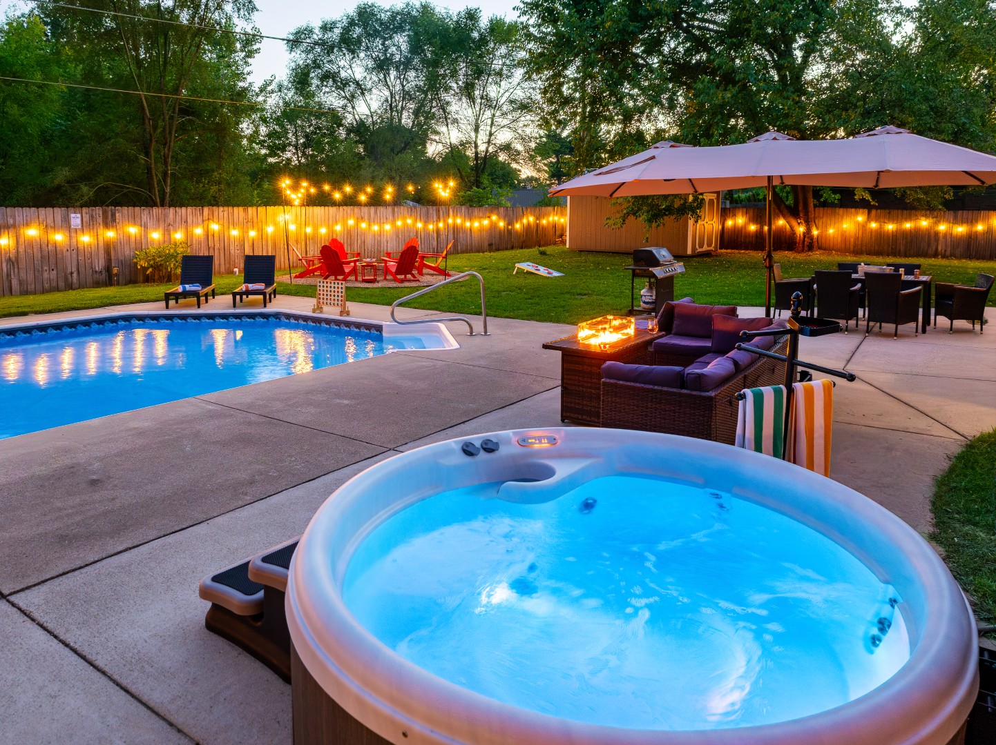 Backyard with pool, hot tub, and patio lights