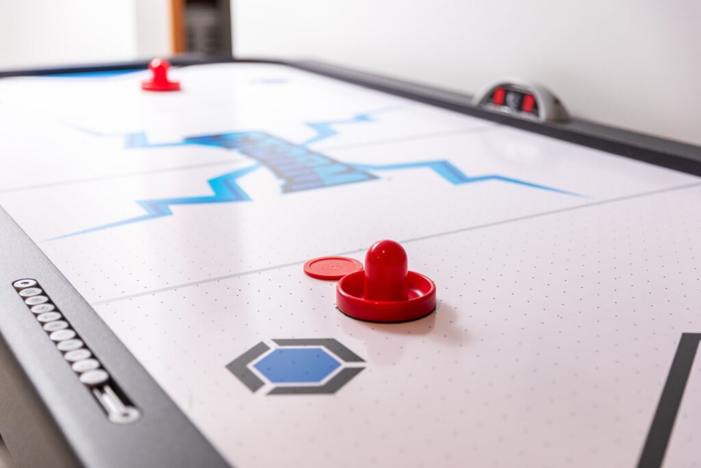Air hockey table with red paddles and puck