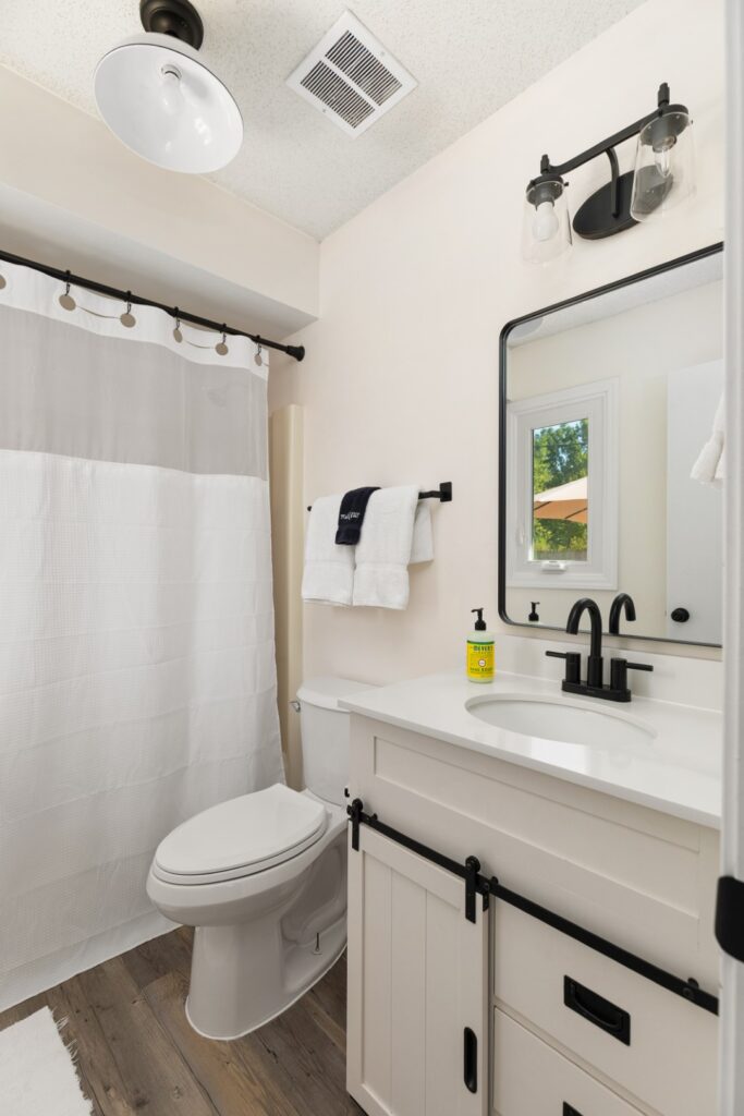 Modern farmhouse bathroom with white vanity and shower.