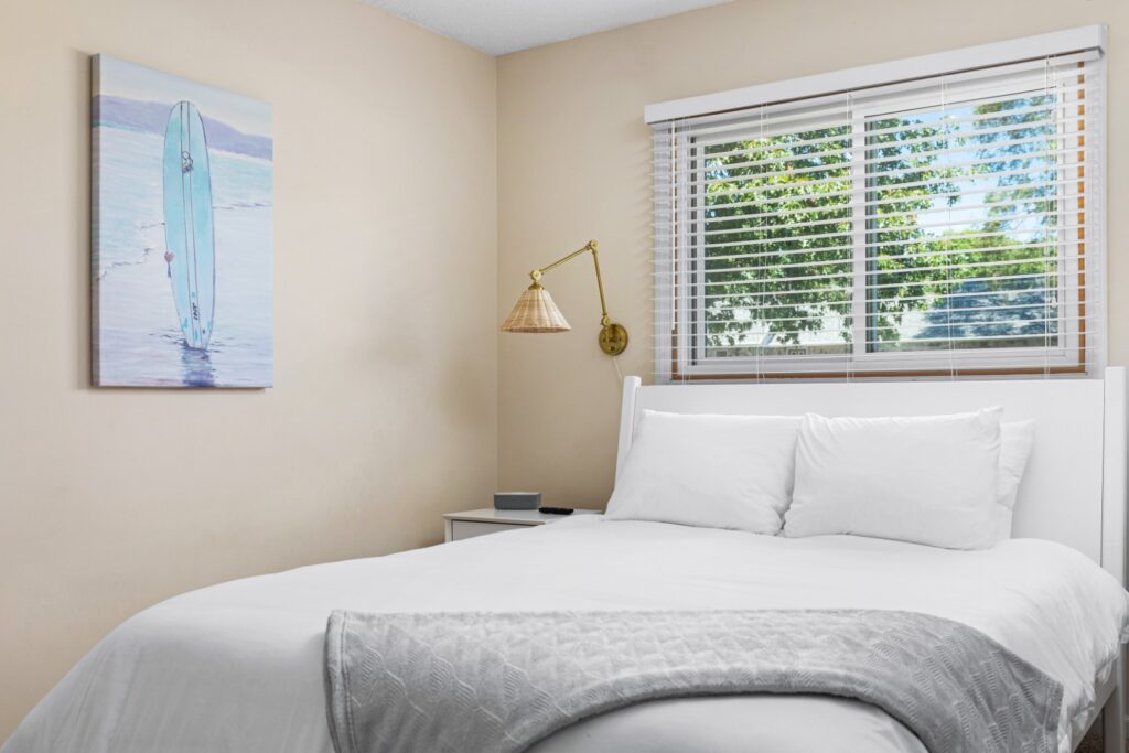 Bright bedroom with white bed and window view