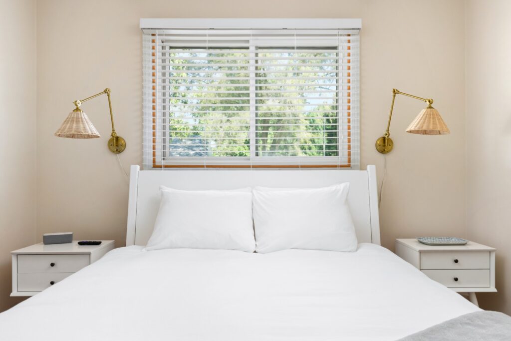Minimalist bedroom with white bed and window
