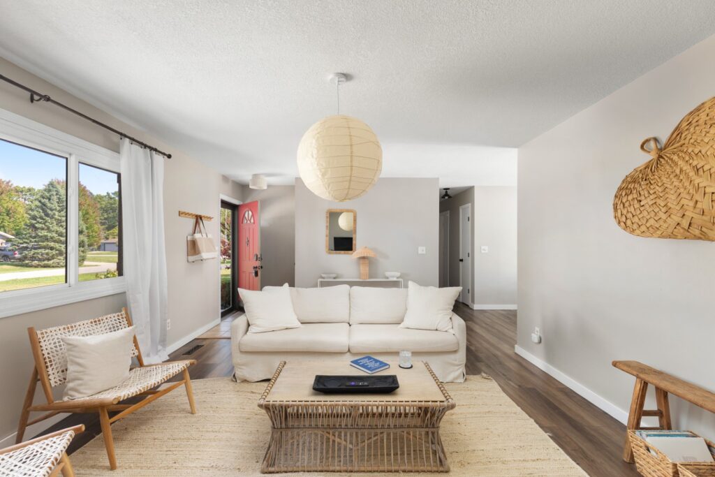 Modern living room with neutral decor and red door