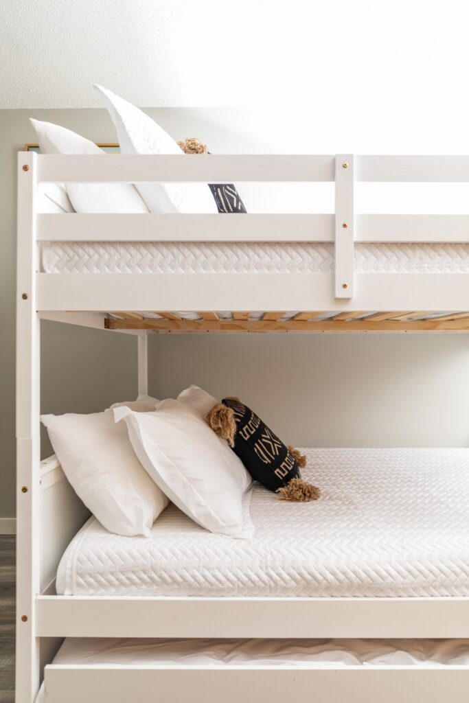 White bunk bed with pillows and cushions